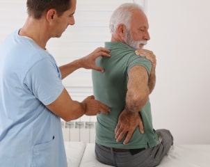 senior man with back pain. spine physical therapist and paient. chiropractic pain relief therapy 1